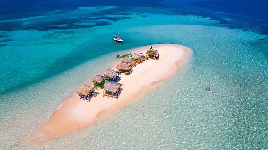 small idle island surrounded by turquoise water