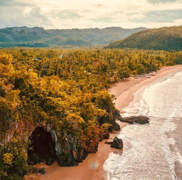 massive rock caves in an isolated beautiful beahc surrounding by palms and mountains