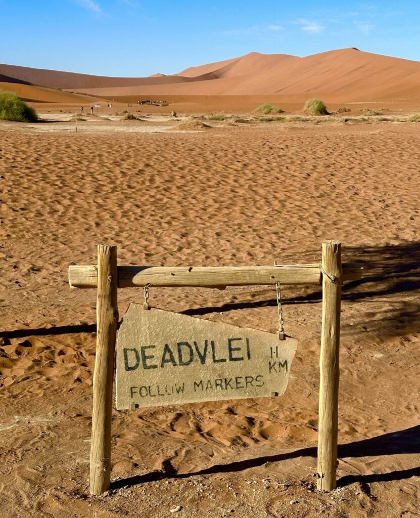 Deadvlie sign with view of tall red dunes and bright blue skies