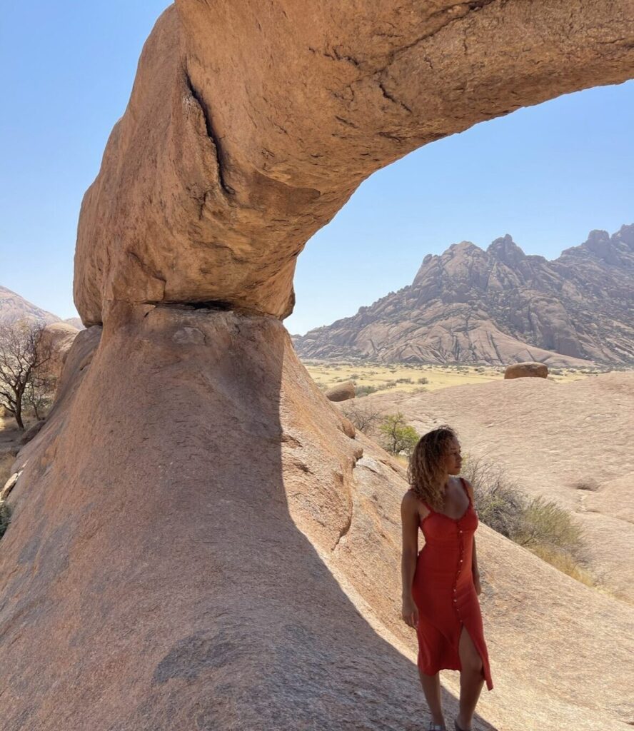 girl in red orange dress in the arch in spitzkoppe arch 